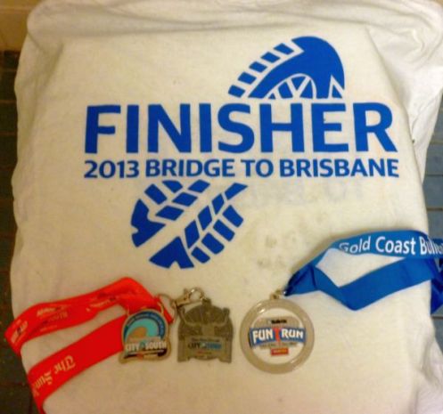 Medals for City2South (LEFT), City2Surf (Middle) and Gold Coast Bulletin Fun Run (Right) draped over the Bridge2Brisbane finishers shirt